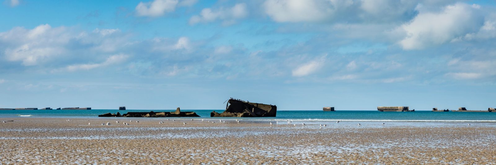 Remains of the artificial harbor in the sea off Arromanches at low tide