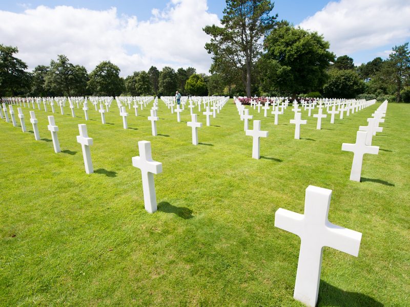 White marble crosses at the Normandy American Cemetery under a blue sky