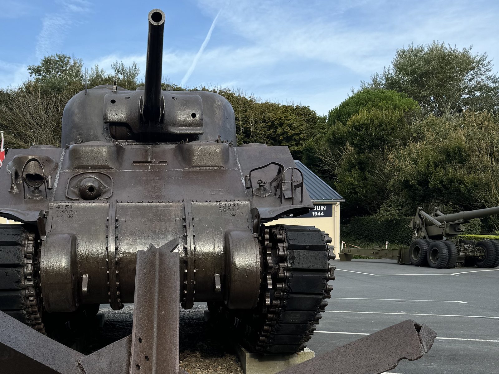A Sherman tank behind a steel beach obstacle at a D-Day memorial site