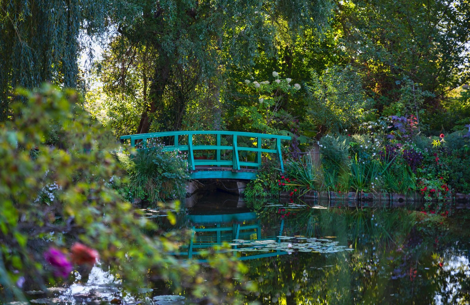 The green Japanese bridge over the water lily pond in Monet's garden at Giverny