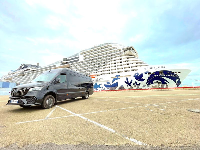 Black Mercedes Sprinter van parked at the Le Havre cruise terminal next to a cruise ship