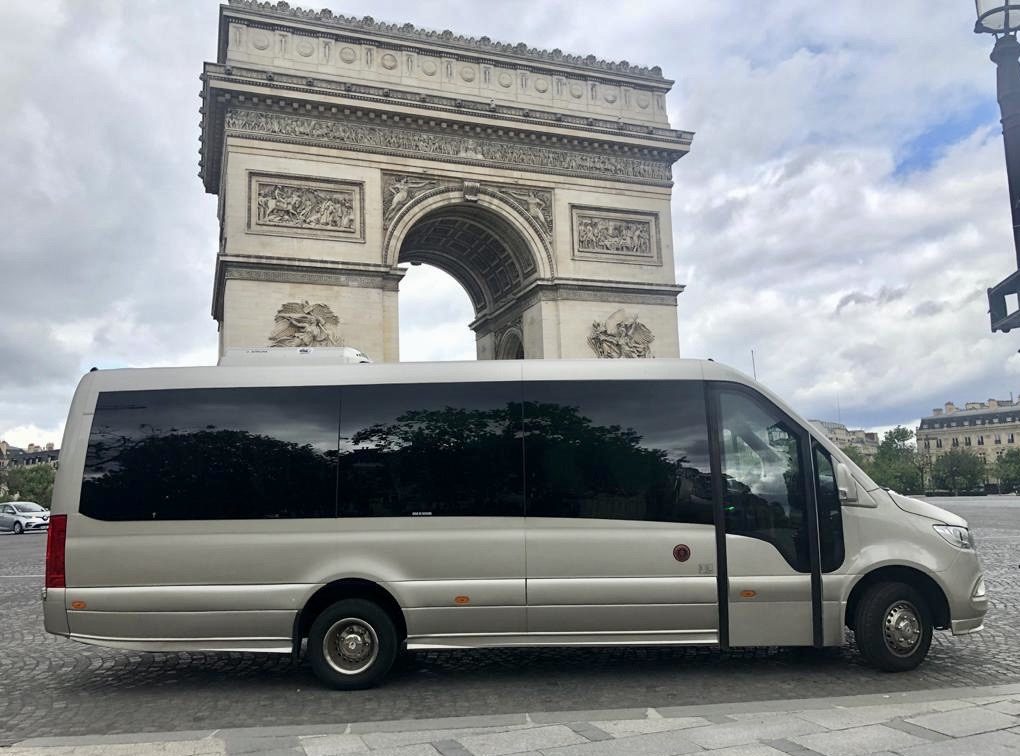 Silver Mercedes Sprinter minibus in front of the Arc de Triomphe in Paris