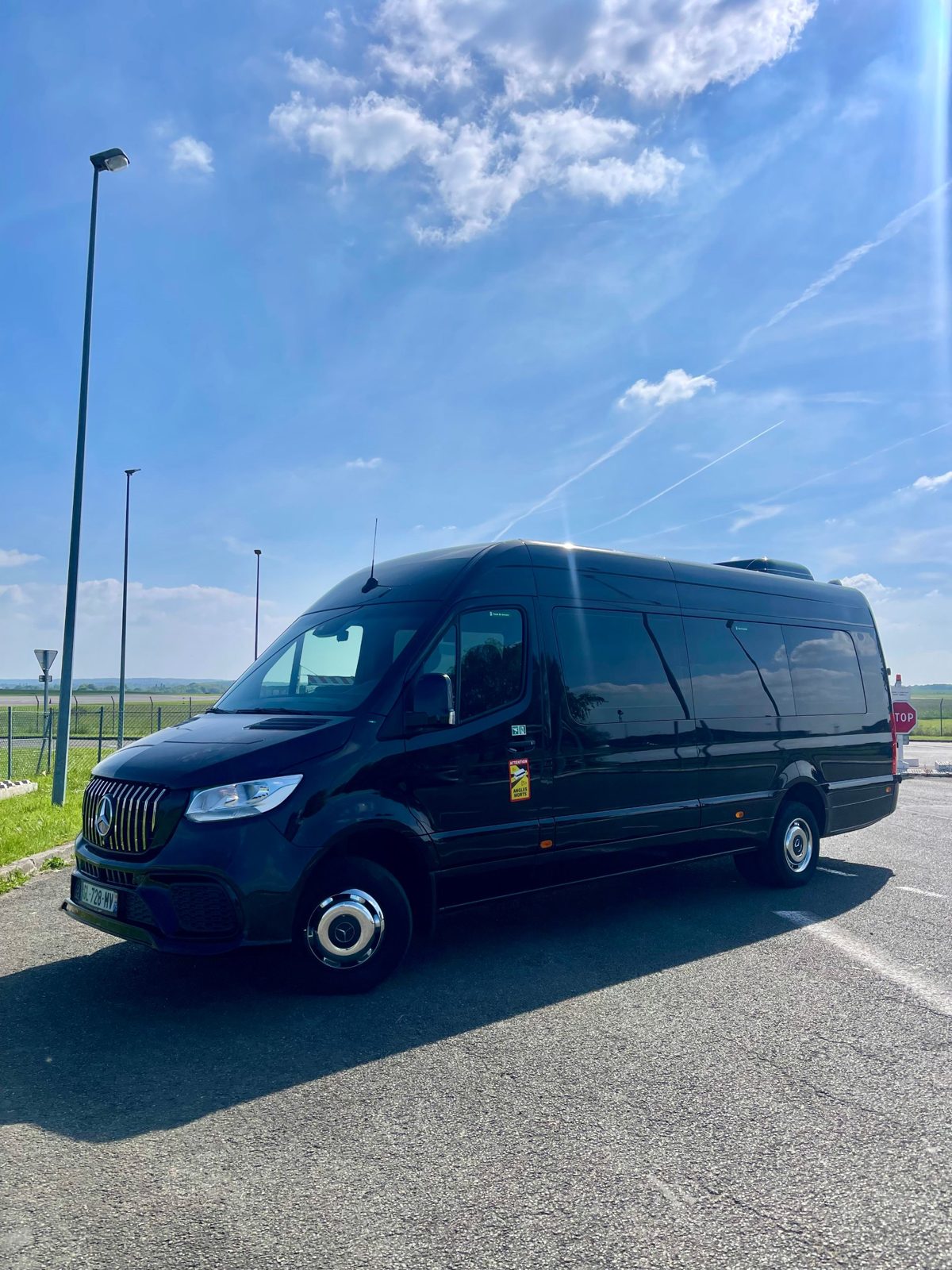 Black Mercedes Sprinter parked near an airport