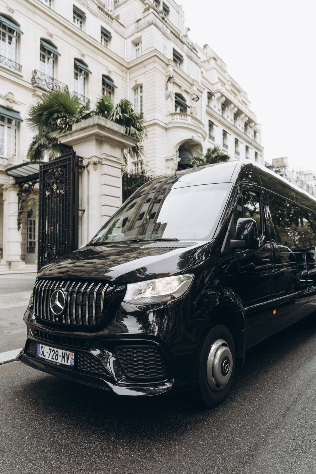 Black Mercedes Sprinter parked outside a Paris hotel