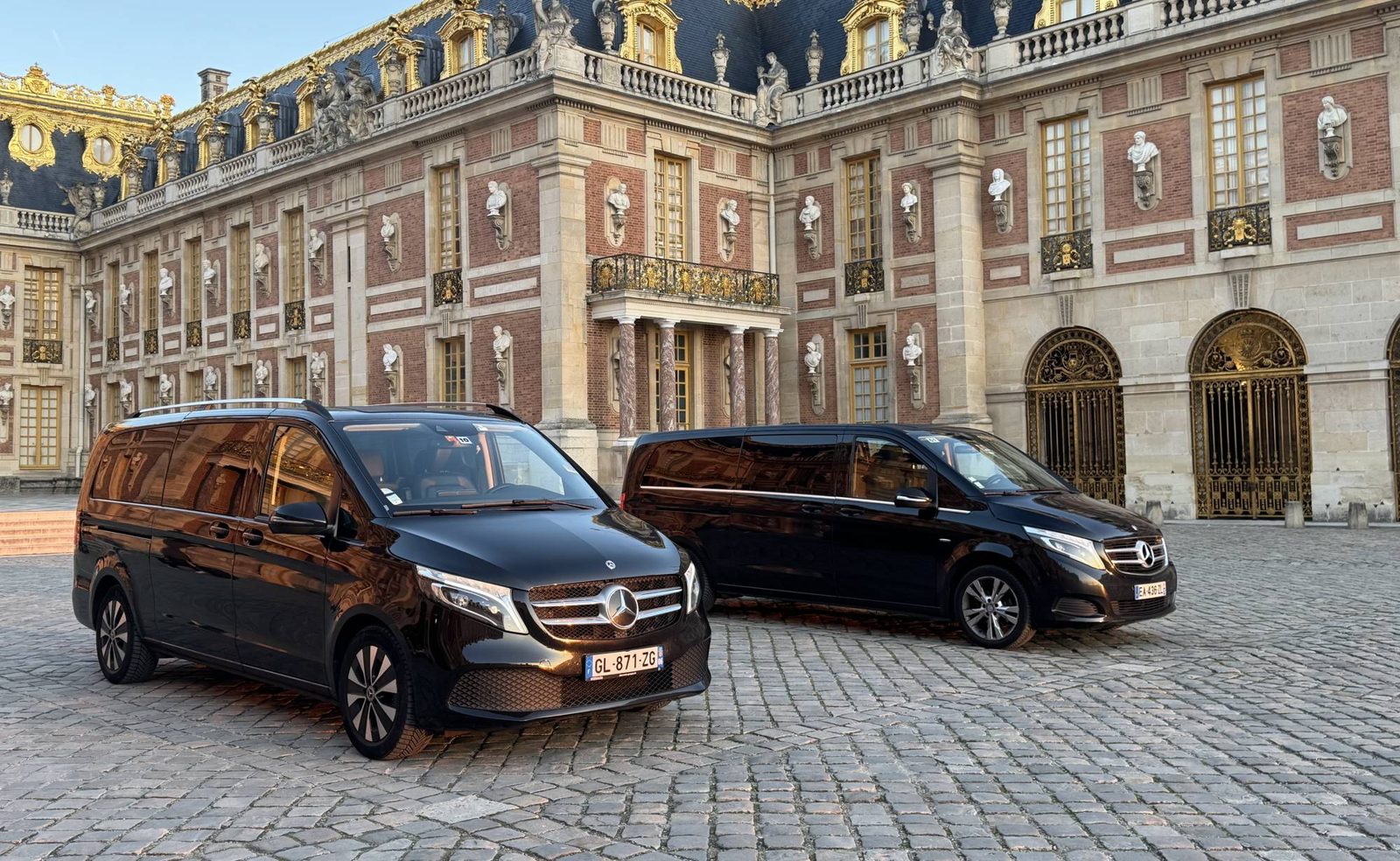 Two black Mercedes V-Class vans in the courtyard of the Palace of Versailles